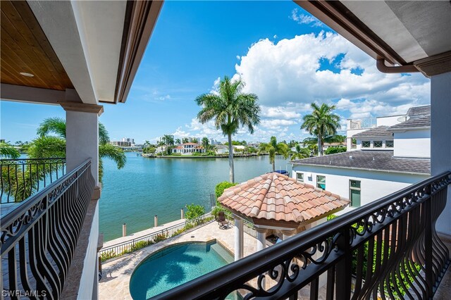 balcony featuring a water view and a fenced in pool