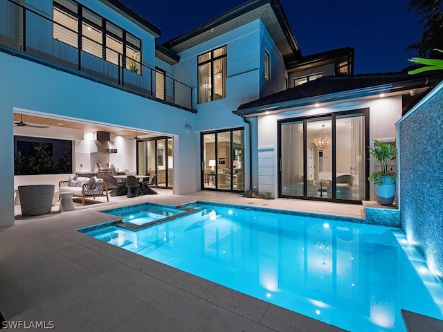 pool at twilight featuring an outdoor hangout area, an in ground hot tub, and a patio area