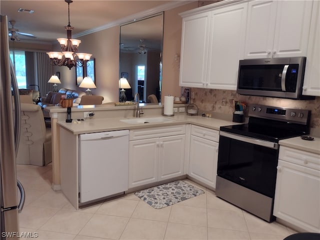 kitchen with ceiling fan with notable chandelier, sink, stainless steel appliances, white cabinets, and ornamental molding