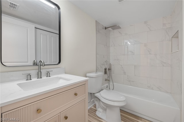 full bathroom featuring tiled shower / bath, oversized vanity, toilet, and wood-type flooring