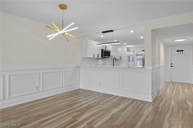 interior space featuring a chandelier, light wood-type flooring, and sink