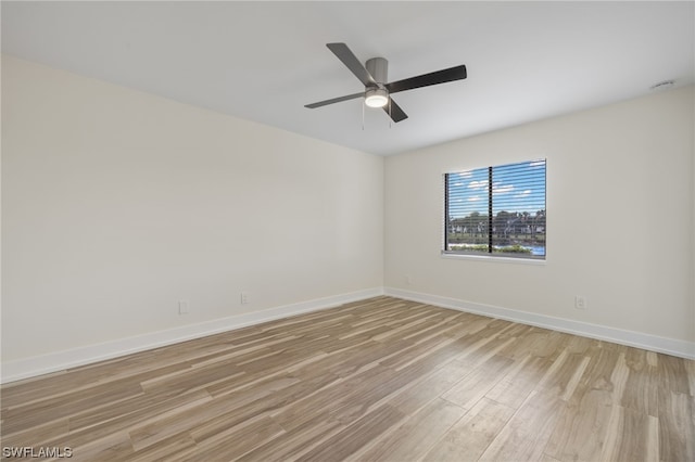 empty room with ceiling fan and light hardwood / wood-style flooring