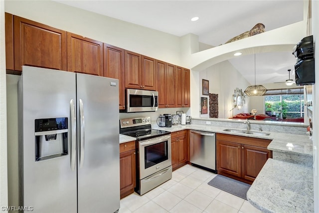 kitchen with lofted ceiling, decorative light fixtures, ceiling fan, appliances with stainless steel finishes, and sink