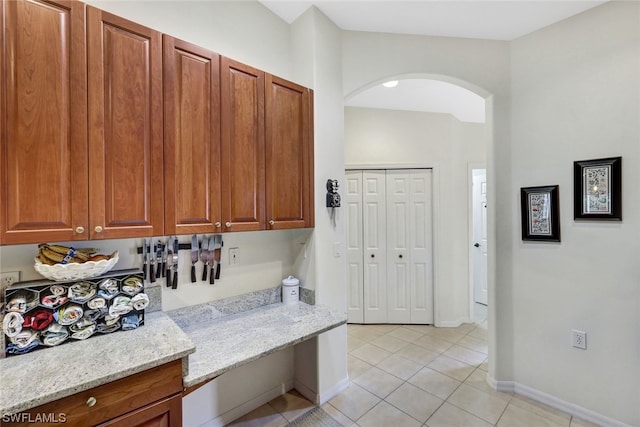 kitchen with light tile floors and light stone countertops