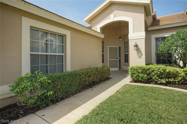 entrance to property with a lawn