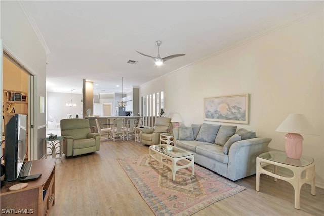 living room with light hardwood / wood-style flooring, ceiling fan, and ornamental molding