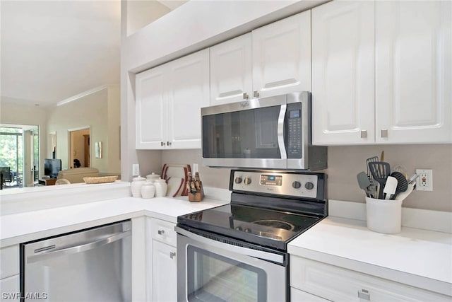 kitchen with white cabinets, stainless steel appliances, and ornamental molding