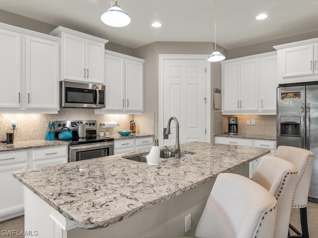 kitchen featuring hanging light fixtures, tasteful backsplash, white cabinetry, and stainless steel appliances