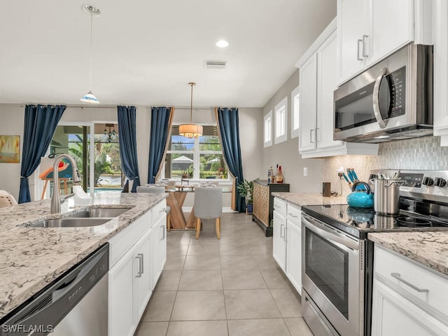 kitchen featuring appliances with stainless steel finishes, plenty of natural light, sink, and light tile flooring