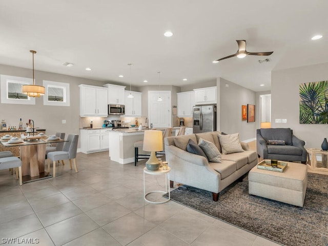 living room featuring light tile floors and ceiling fan