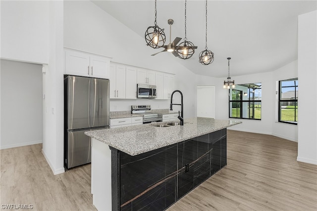 kitchen featuring pendant lighting, white cabinets, appliances with stainless steel finishes, and light hardwood / wood-style flooring