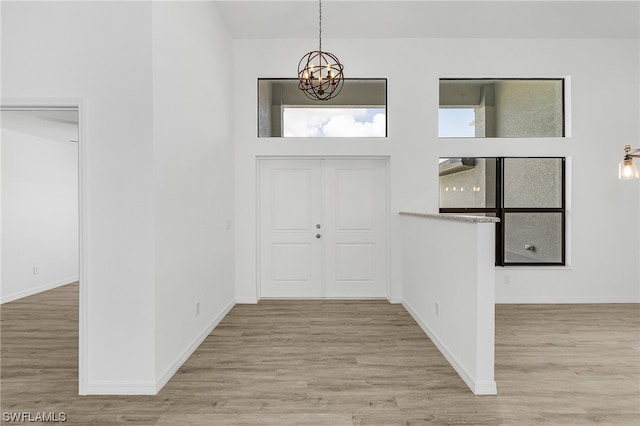 entryway featuring a chandelier and light hardwood / wood-style flooring