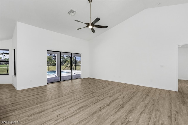 empty room with high vaulted ceiling, ceiling fan, and light wood-type flooring