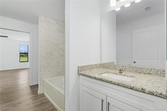 bathroom featuring vanity, tiled shower / bath, and wood-type flooring