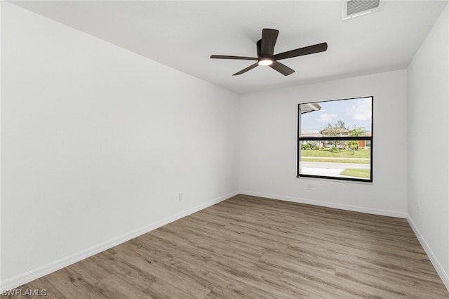 empty room with ceiling fan and light hardwood / wood-style flooring