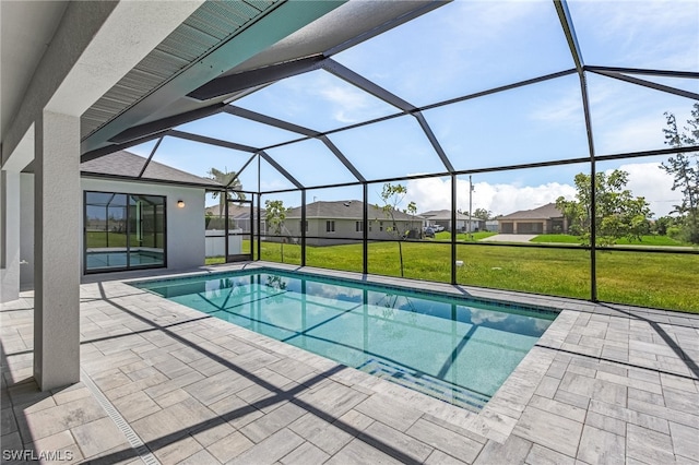 view of pool with a yard, a patio area, and glass enclosure