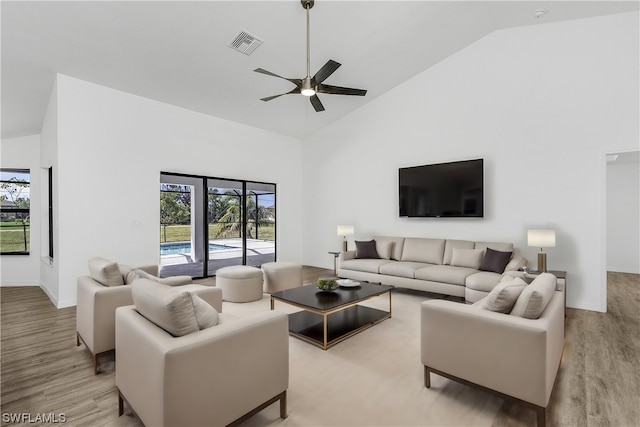 living room featuring light hardwood / wood-style floors, ceiling fan, and high vaulted ceiling