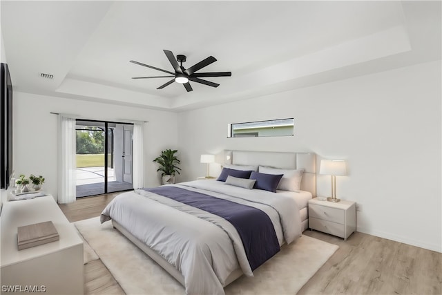 bedroom with a tray ceiling, ceiling fan, access to outside, and light wood-type flooring