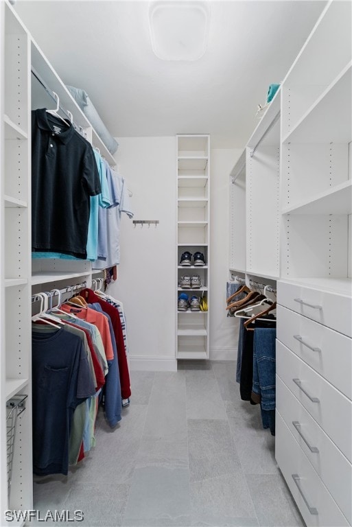 walk in closet featuring light tile floors