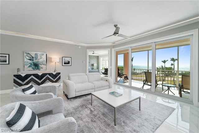 tiled living room featuring plenty of natural light, a water view, ornamental molding, and ceiling fan