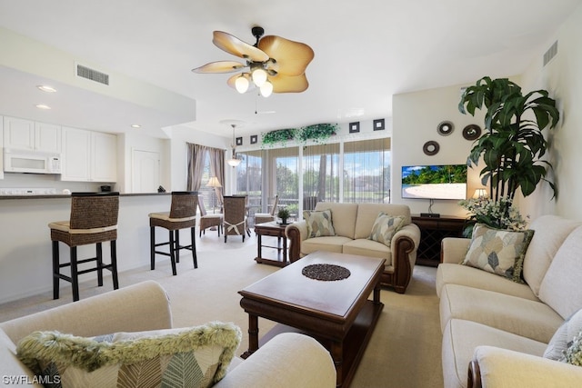 living room with light carpet and ceiling fan