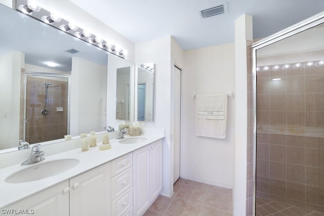 bathroom featuring vanity with extensive cabinet space, dual sinks, tile floors, and an enclosed shower