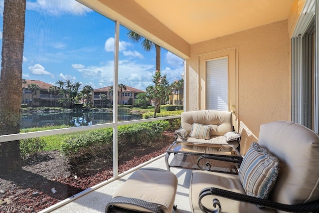 sunroom featuring a water view