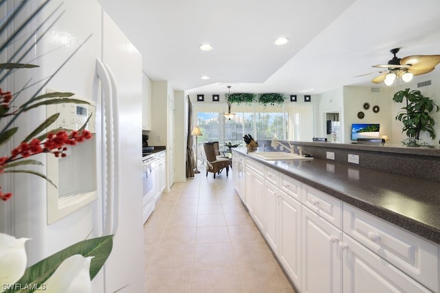 kitchen featuring light tile flooring, ceiling fan, white fridge with ice dispenser, white cabinetry, and sink