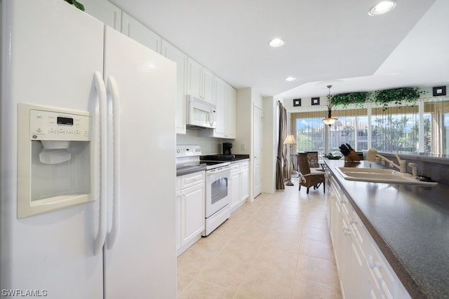 kitchen featuring white appliances, sink, light tile floors, hanging light fixtures, and white cabinetry