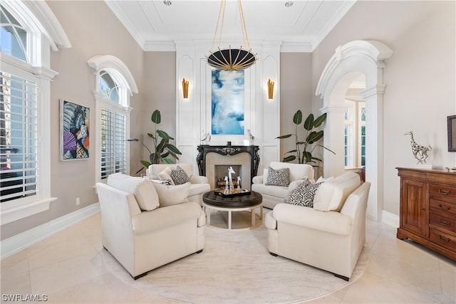 tiled living room featuring ornate columns, a fireplace, and ornamental molding