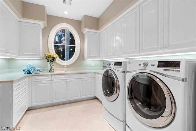 laundry room with light tile patterned flooring, cabinets, and separate washer and dryer