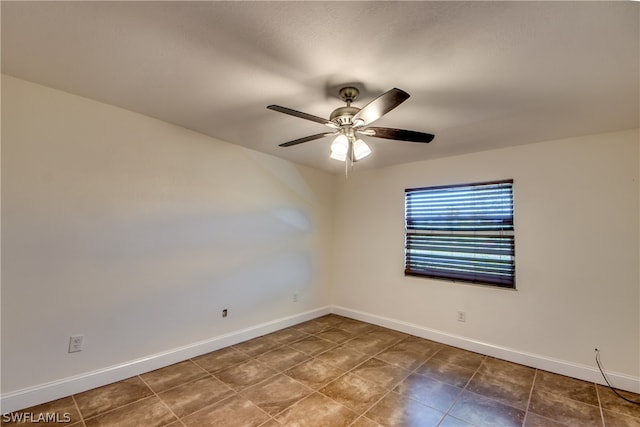 tiled spare room with ceiling fan