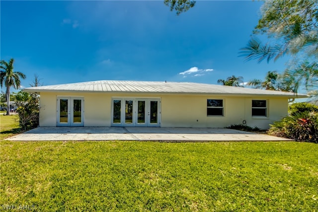 rear view of property featuring a patio area, french doors, and a lawn