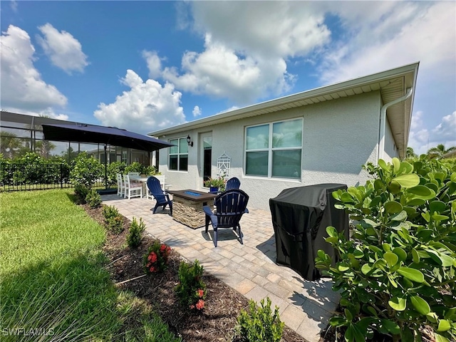 rear view of property featuring a patio area, a fire pit, and a yard