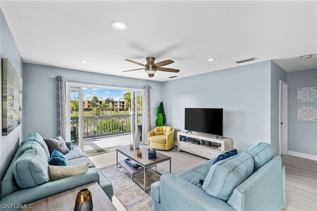 living room featuring ceiling fan and light hardwood / wood-style flooring