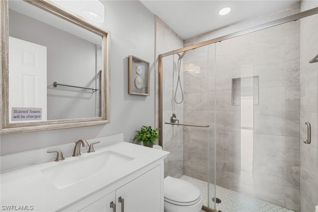 bathroom with walk in shower, large vanity, and toilet