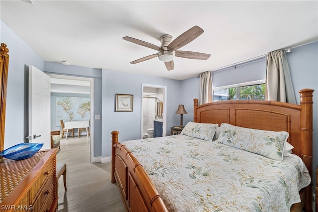 bedroom with ensuite bathroom, ceiling fan, and light wood-type flooring