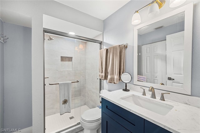 bathroom with a shower with shower door, oversized vanity, and toilet