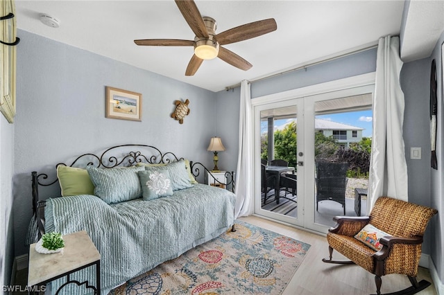 bedroom featuring ceiling fan, light hardwood / wood-style floors, access to outside, and french doors