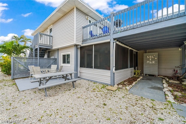 back of house featuring a balcony and a sunroom