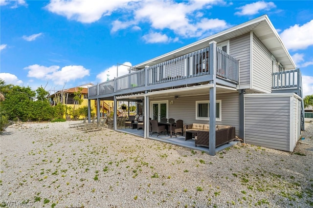 rear view of property with a wooden deck, an outdoor hangout area, and a patio area