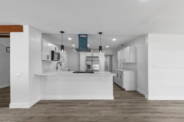 kitchen featuring island exhaust hood, stainless steel appliances, pendant lighting, hardwood / wood-style flooring, and white cabinetry