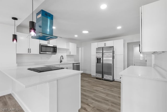 kitchen with stainless steel appliances, island exhaust hood, light hardwood / wood-style floors, and decorative light fixtures