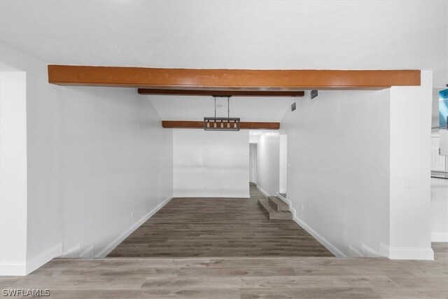 interior space with wood-type flooring and beam ceiling