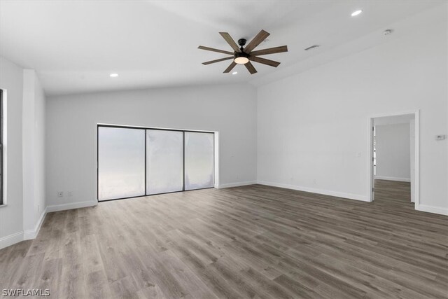 empty room featuring high vaulted ceiling, wood-type flooring, and ceiling fan