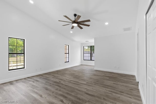 spare room featuring a wealth of natural light, dark wood-type flooring, high vaulted ceiling, and ceiling fan