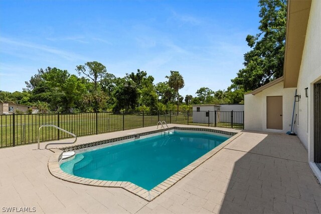 view of swimming pool with a patio and a yard