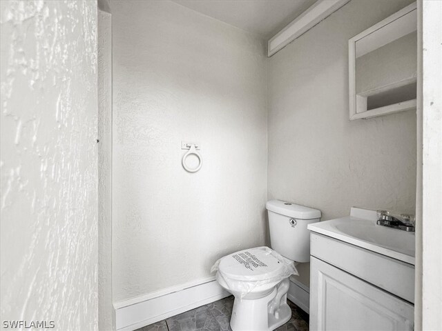 bathroom with tile floors, toilet, and oversized vanity