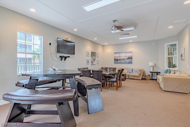 dining space featuring light colored carpet and ceiling fan