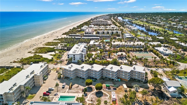 birds eye view of property with a water view and a beach view